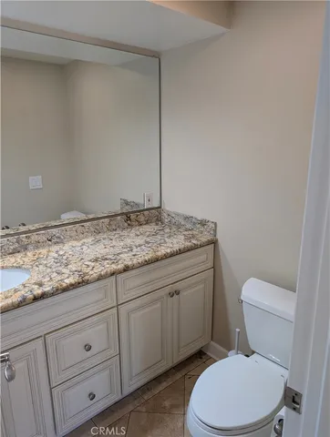 a bathroom with a granite countertop toilet and sink