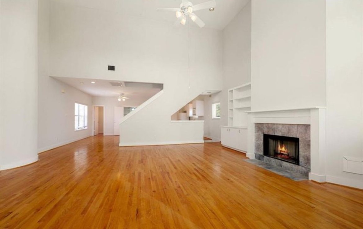 5509 Cornish Street Houston, TX 77007 - Photo 6 of 15 a view of an empty room with wooden floor fireplace and a window