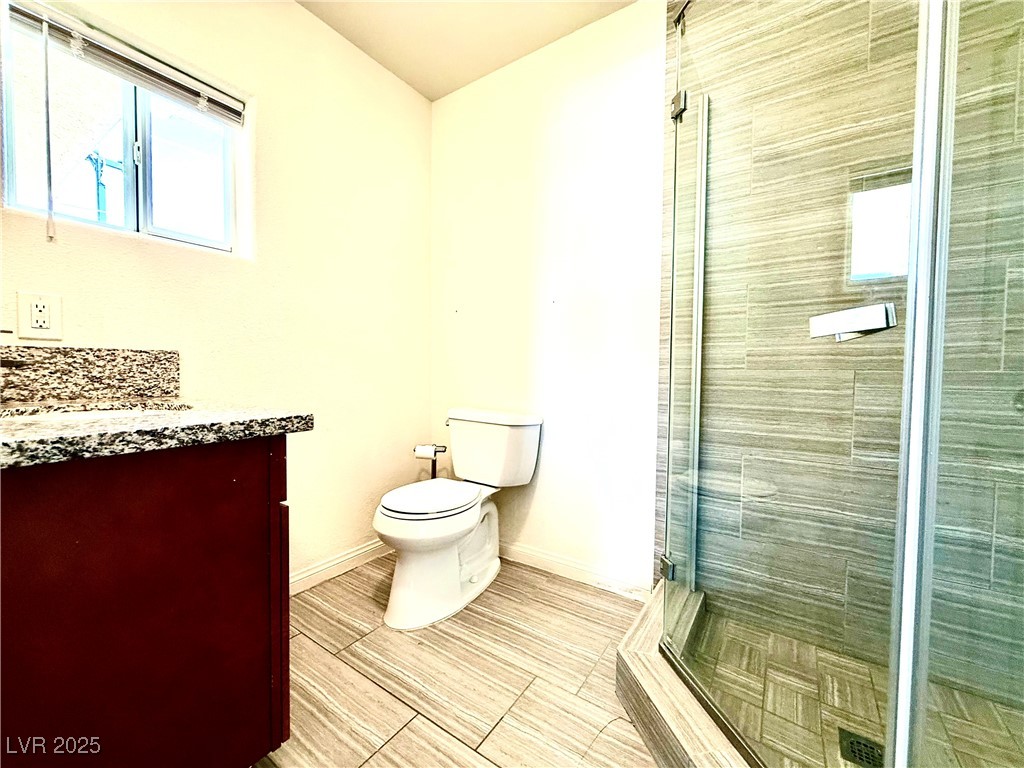 764 Benedict Drive Las Vegas, NV 89110 - Photo 14 of 30 Bathroom with toilet, vanity, a shower stall, and
