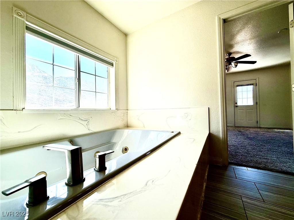 764 Benedict Drive Las Vegas, NV 89110 - Photo 23 of 30 Bathroom with ceiling fan and a whirlpool tub