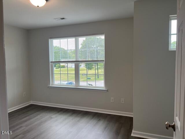 415 Aversboro Road Garner, NC 27529 - Photo 31 of 32 an empty room with wooden floor and windows