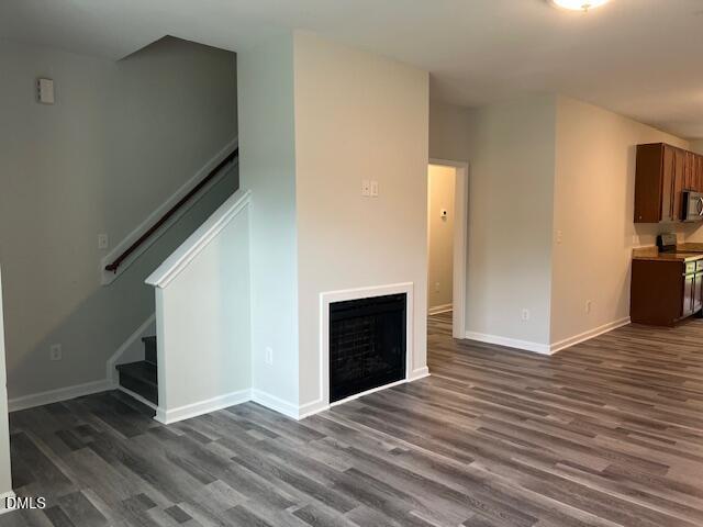 415 Aversboro Road Garner, NC 27529 - Photo 9 of 32 a view of an empty room with wooden floor and a fireplace