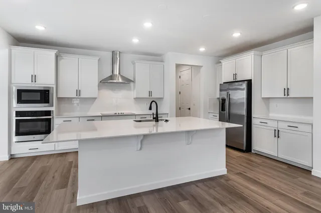 a large kitchen with stainless steel appliances a sink and a refrigerator