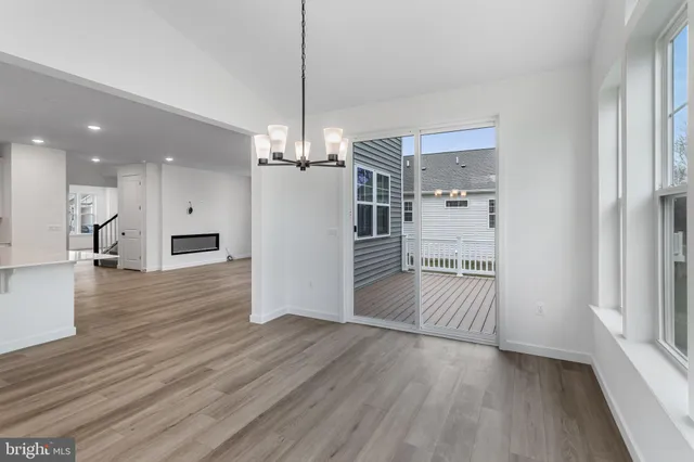 a view of a room with wooden floor staircase and a kitchen