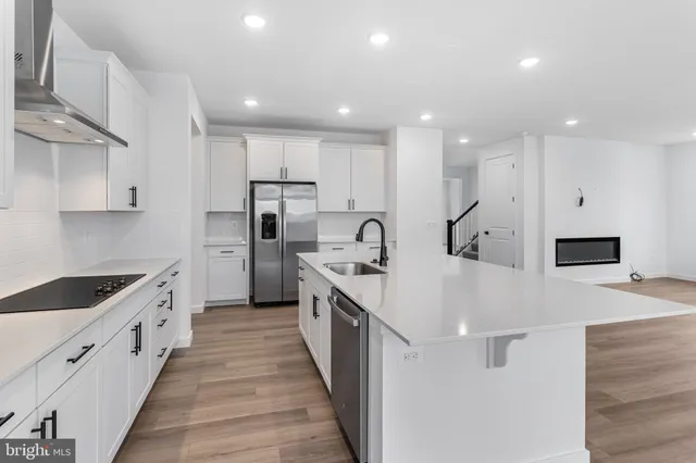 a large white kitchen with lots of counter space a sink refrigerator and a stove