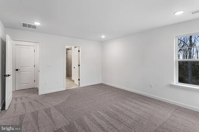 an empty room with windows and closet