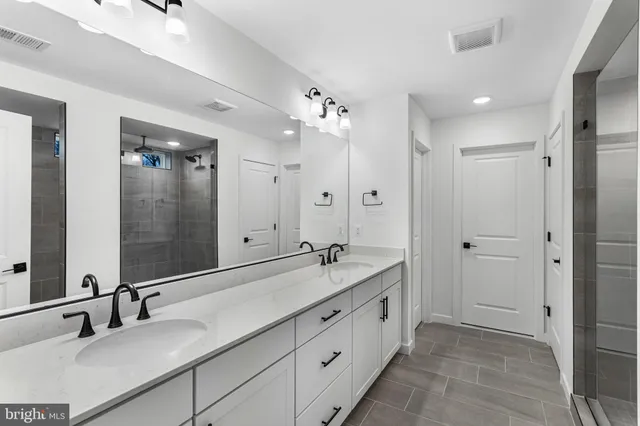 a bathroom with double vanity sinks and a mirror