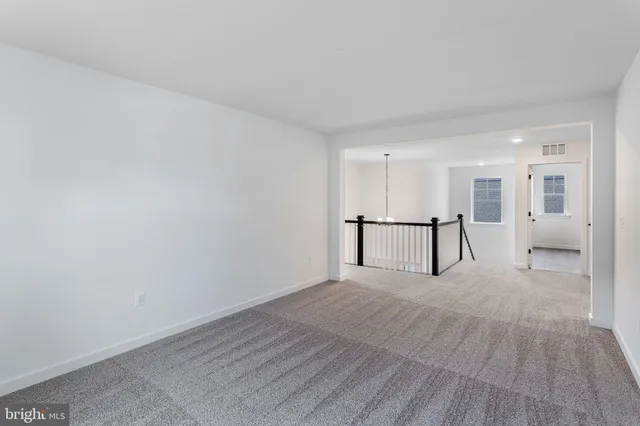 a view of an empty room with wooden floor and a large window