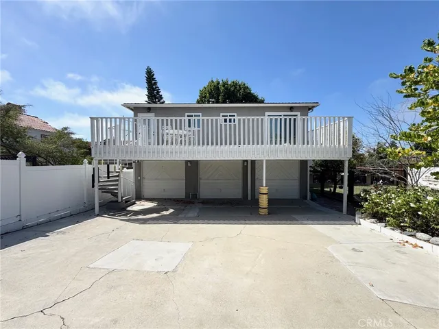 a view of a house with a wooden deck and furniture