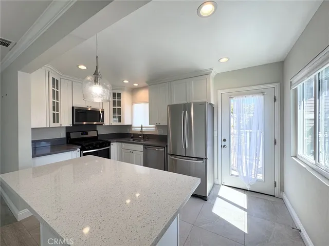 a view of kitchen with wooden floor and stainless steel appliances