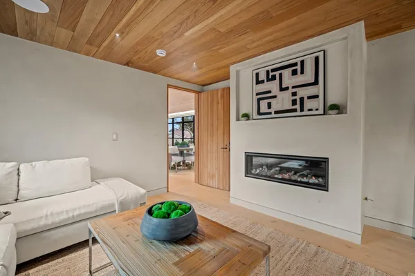 a living room with furniture large window and fireplace