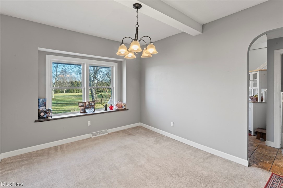4275 West Calla Road Canfield, OH 44406 - Photo 9 of 31 Spare room with an inviting chandelier, beamed ceiling, and light colored carpet