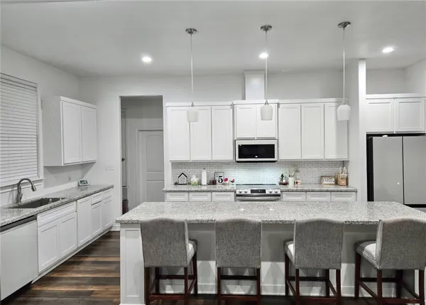 a kitchen with granite countertop a sink and cabinets