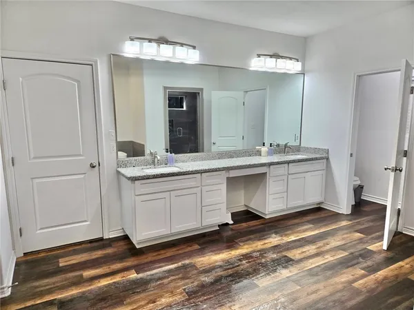 a spacious bathroom with a granite countertop sink and a mirror