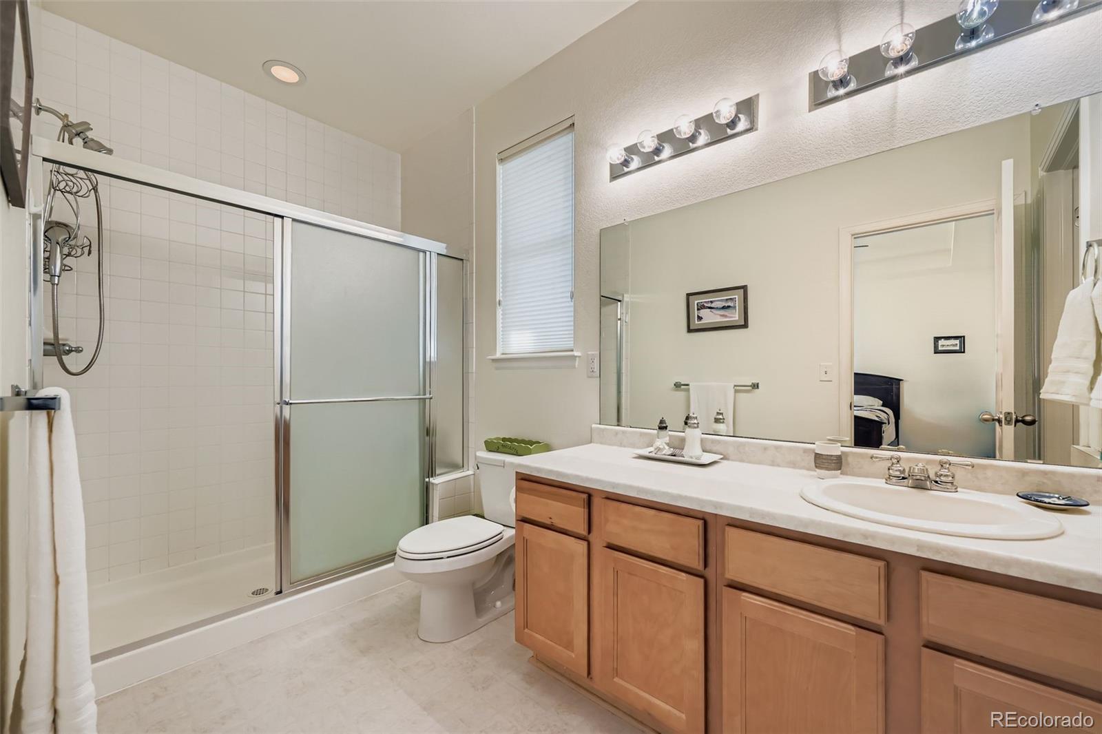 4712 Sandy Ridge Avenue Firestone, CO 80504 - Photo 16 of 29 a bathroom with a double vanity sink toilet mirror and shower