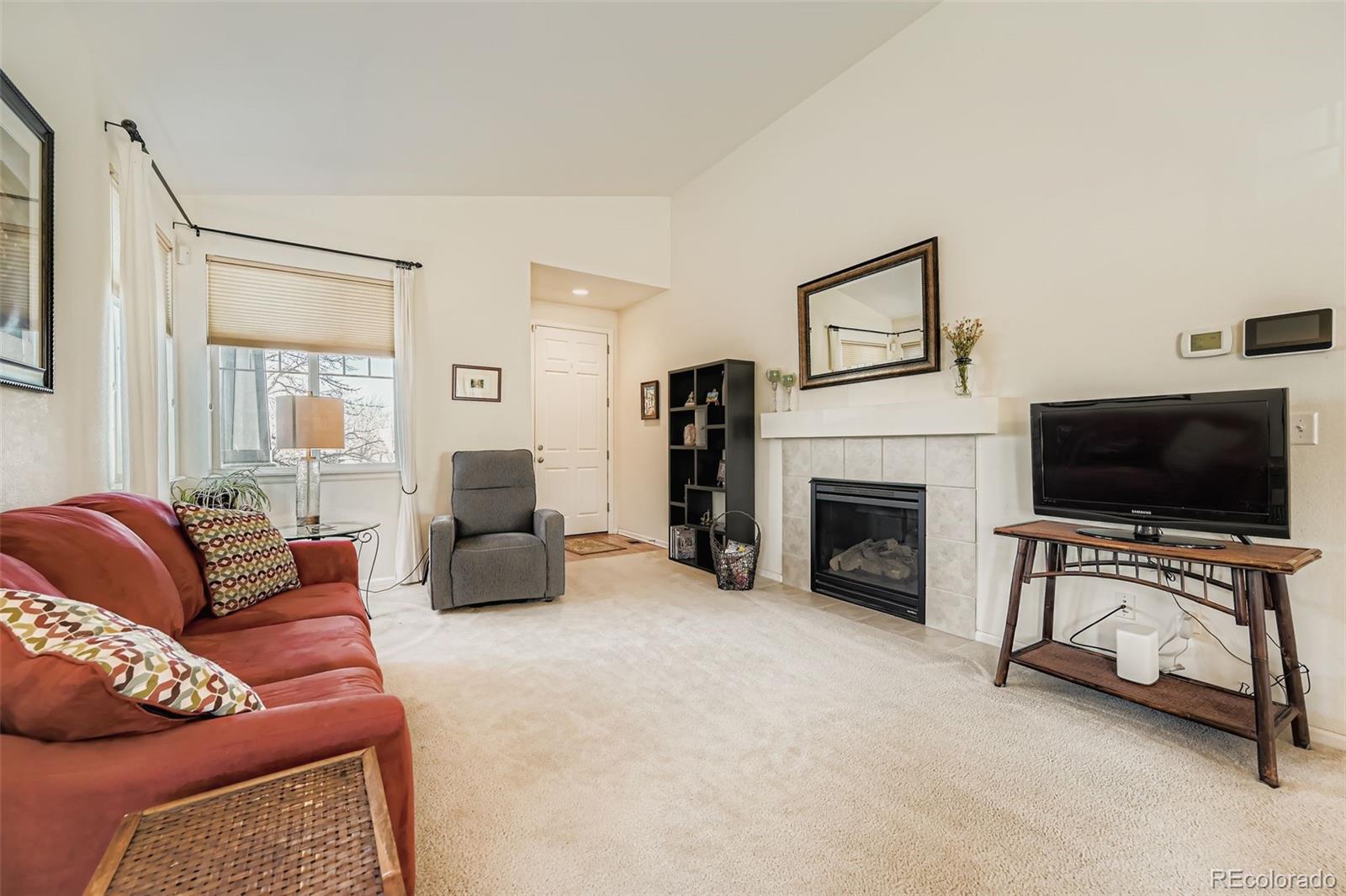 4712 Sandy Ridge Avenue Firestone, CO 80504 - Photo 6 of 29 a living room with furniture a flat screen tv and a fireplace