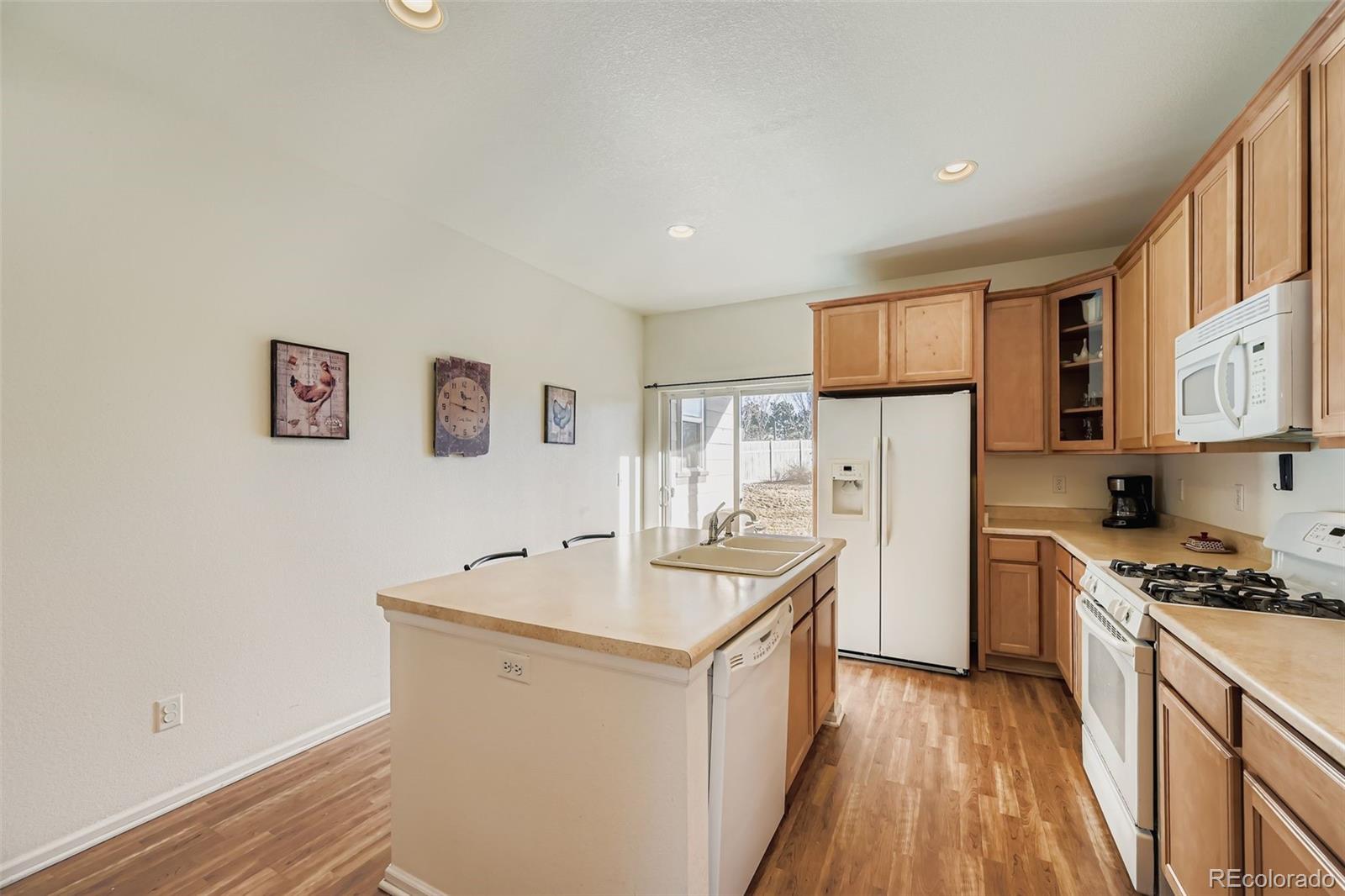 4712 Sandy Ridge Avenue Firestone, CO 80504 - Photo 9 of 29 a kitchen with sink a refrigerator and white cabinets
