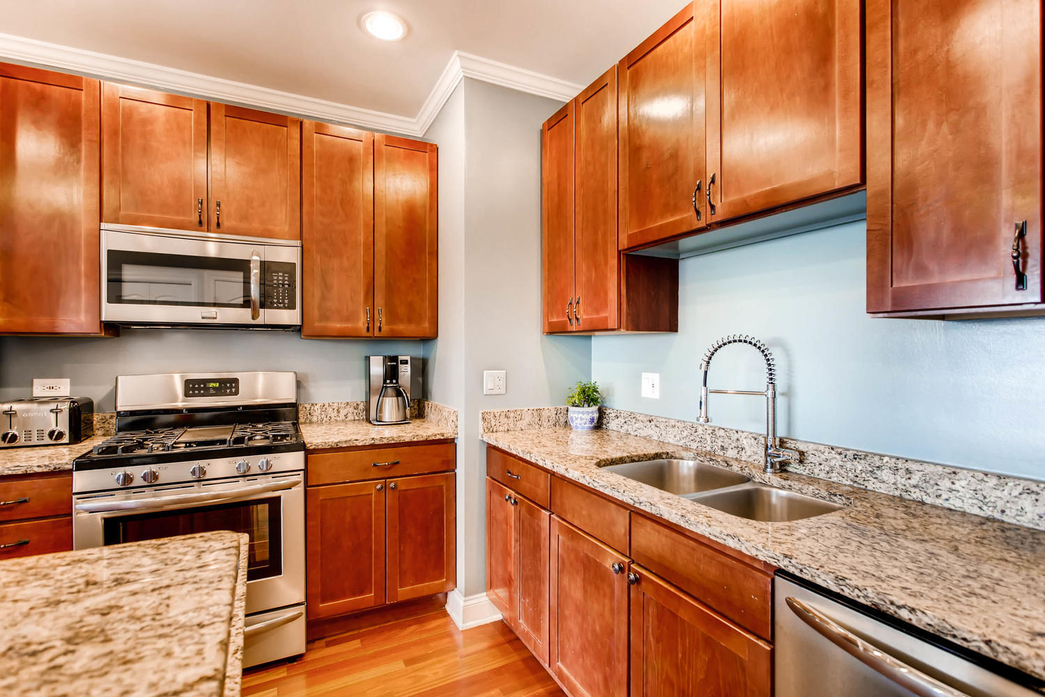 1242 West Pratt Boulevard, Unit 3F Chicago, IL 60626 - Photo 12 of 30 a kitchen with stainless steel appliances granite countertop wooden cabinets a stove a sink and dishwasher