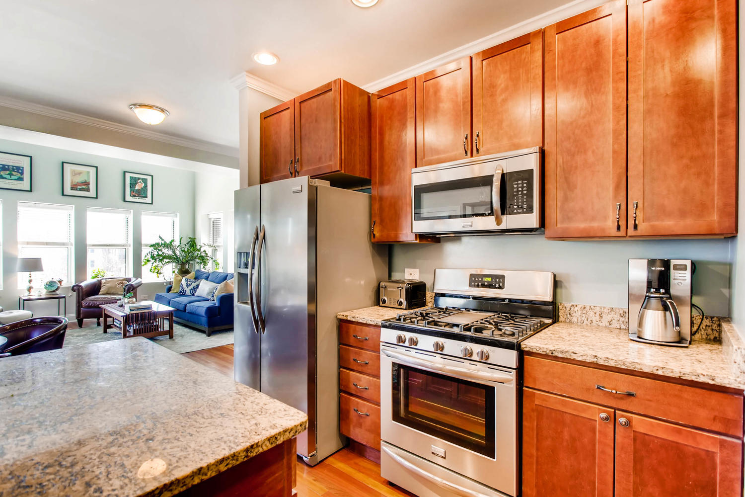 1242 West Pratt Boulevard, Unit 3F Chicago, IL 60626 - Photo 13 of 30 a kitchen with stainless steel appliances granite countertop a stove a refrigerator and a microwave