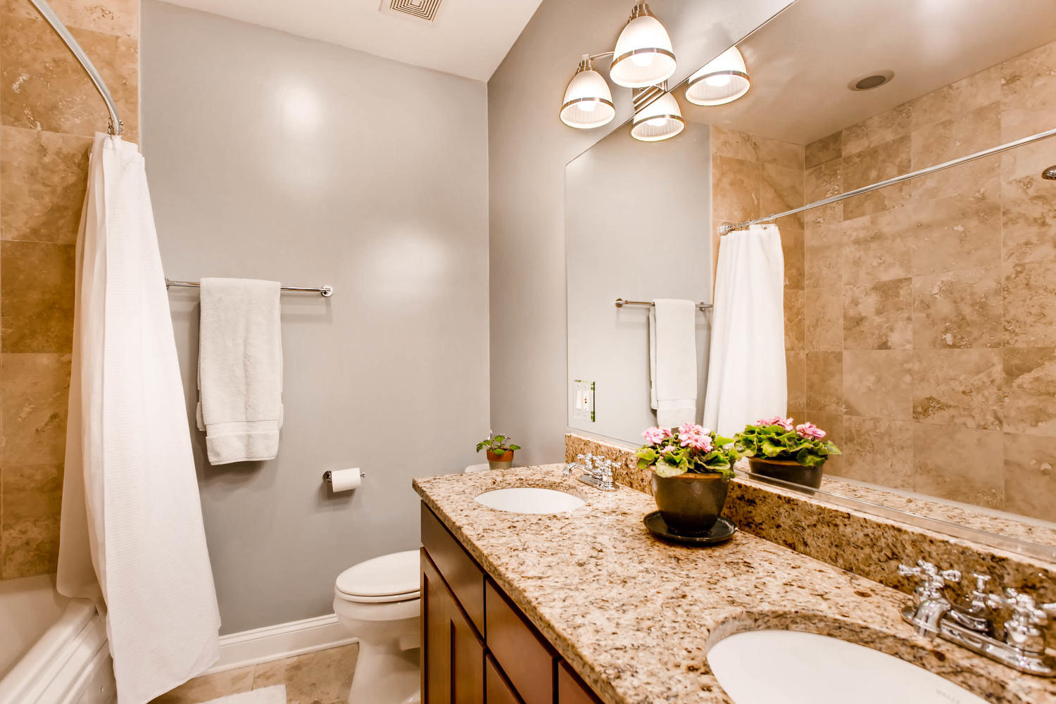 1242 West Pratt Boulevard, Unit 3F Chicago, IL 60626 - Photo 17 of 30 a bathroom with a granite countertop sink a toilet and a mirror