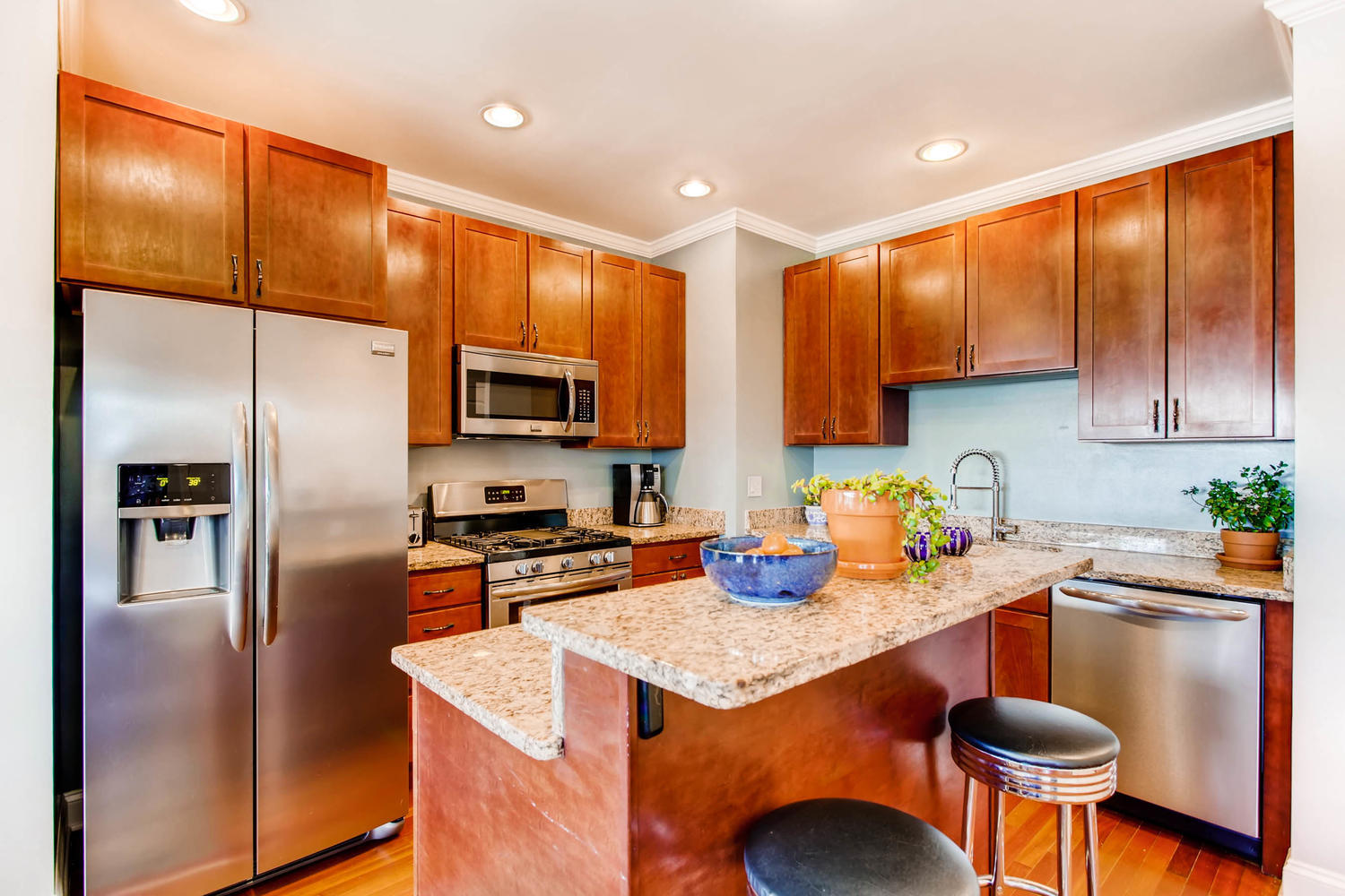 1242 West Pratt Boulevard, Unit 3F Chicago, IL 60626 - Photo 10 of 30 a kitchen with stainless steel appliances granite countertop a refrigerator a stove a sink cabinets and a dining table with wooden floor