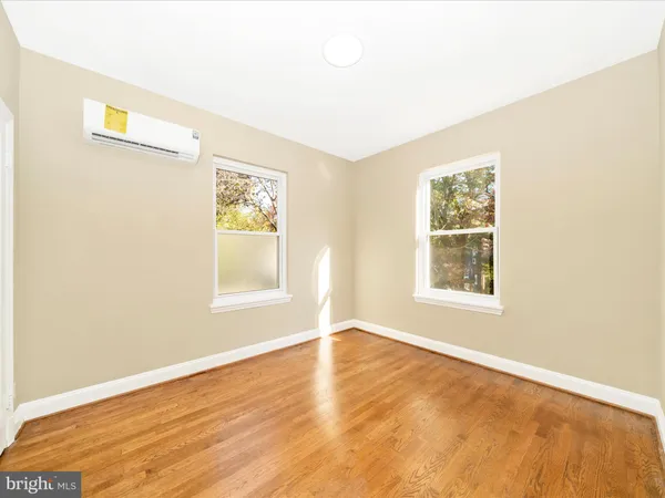 an empty room with wooden floor and a window