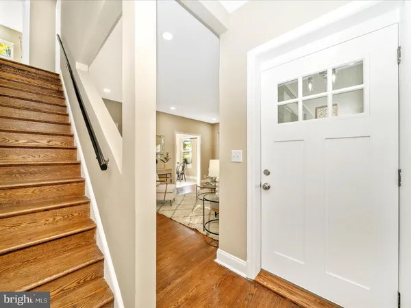 a view of a hallway with wooden floor and staircase