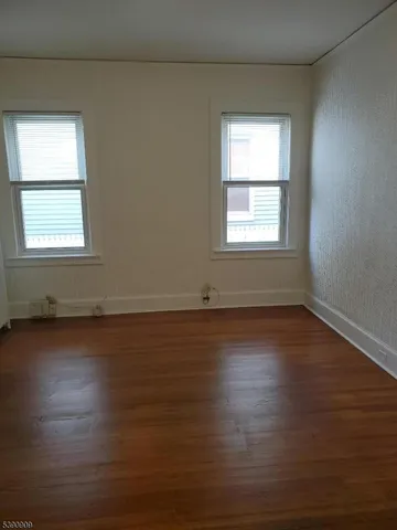 a bedroom with a bed and two windows