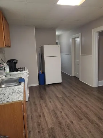 a kitchen with a wooden floor and cabinets