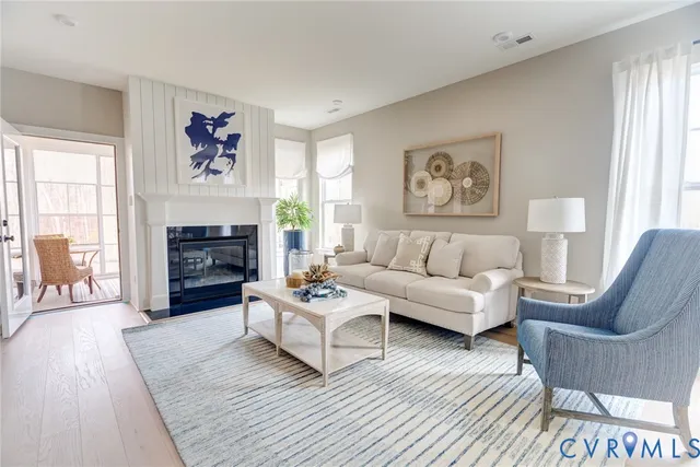 a living room with furniture a flat screen tv and a fireplace