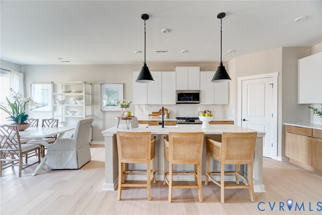 0 Canoe Pointe Loop Henrico, VA 23238 - Photo 2 of 32 a kitchen with stainless steel appliances kitchen island granite countertop a dining table chairs and white cabinets