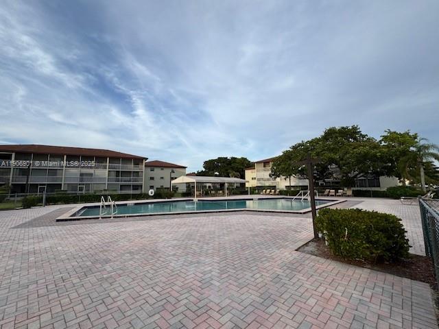 13455 Southwest 3rd Street, Unit 309S Pembroke Pines, FL 33027 - Photo 13 of 23 a view of swimming pool with lawn chairs and iron fence