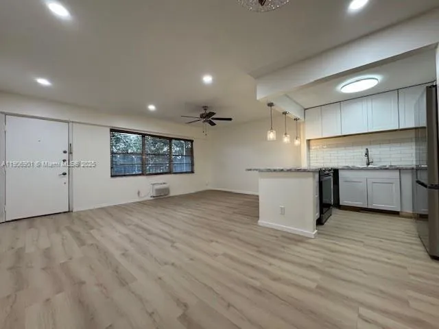 a view of a kitchen with a sink and wooden floor