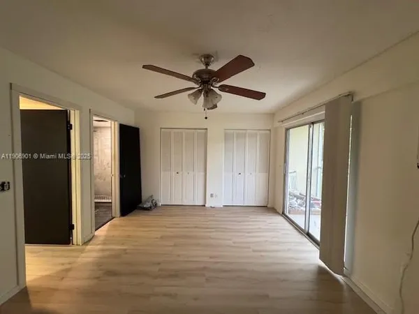 a view of a livingroom with a chandelier fan and a window