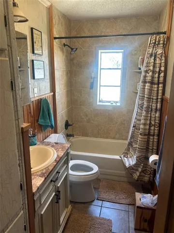 a bathroom with a sink a toilet a mirror a tub and shower