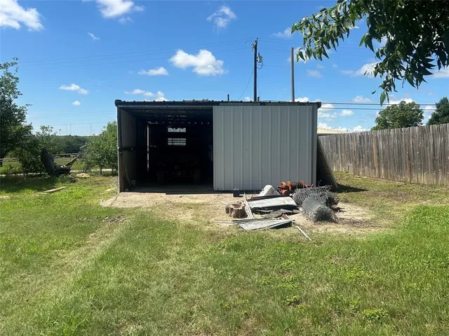 a view of a backyard with a table and chairs with wooden fence