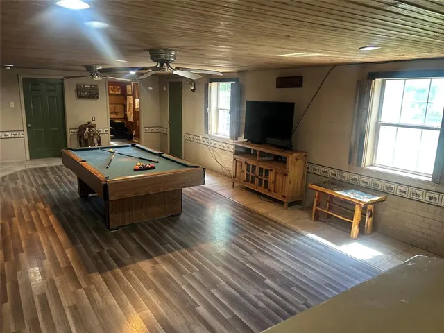 a living room with furniture flat screen tv and window