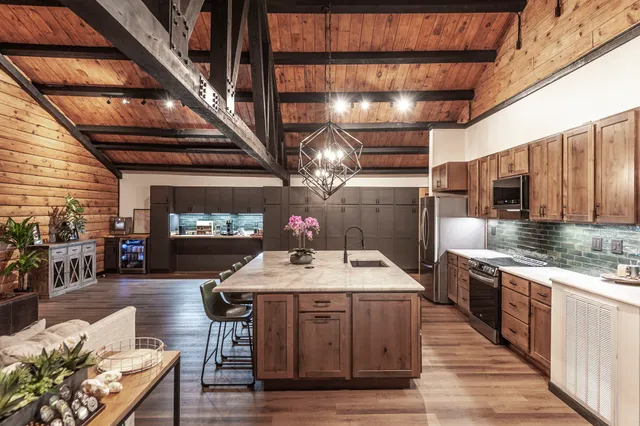 a kitchen with stainless steel appliances granite countertop a sink dishwasher a stove with wooden cabinets and floor