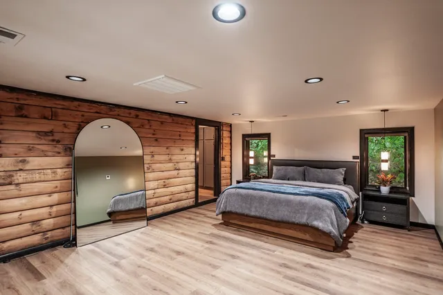 a view of a hallway with wooden floor and windows