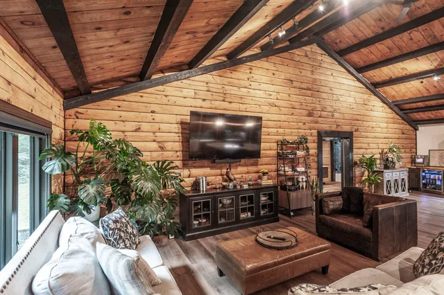 a living room with patio furniture and a flat screen tv