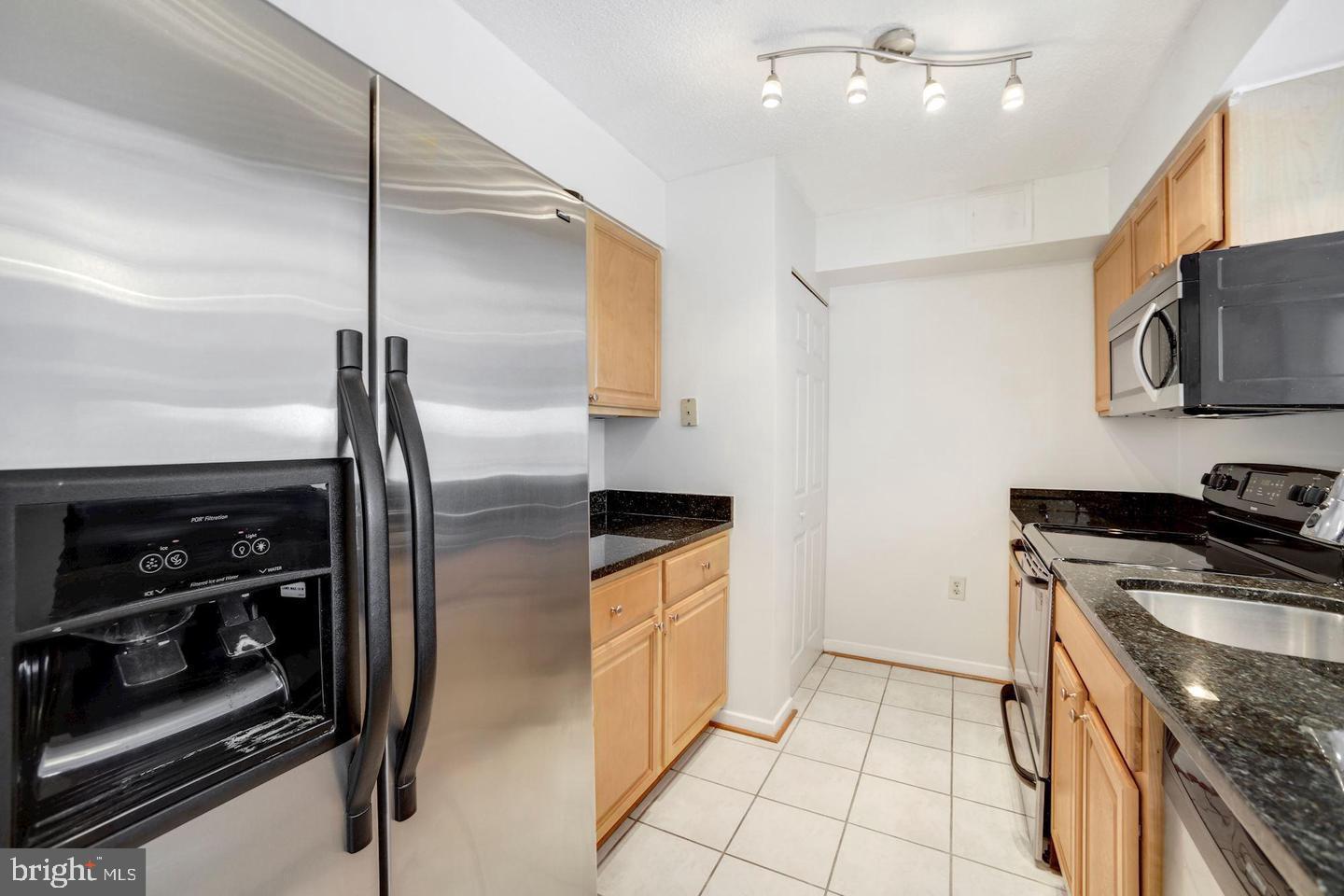 2111 Wisconsin Avenue Northwest, Unit 317 Washington, DC 20007 - Photo 13 of 38 a kitchen with stainless steel appliances granite countertop a sink a stove and a refrigerator