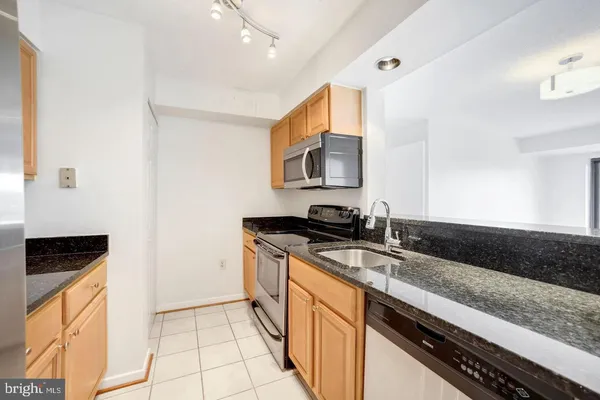 a kitchen with stainless steel appliances granite countertop a sink and a stove