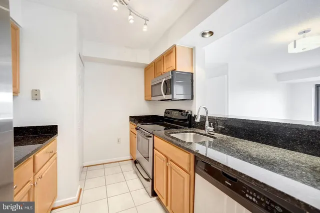 a kitchen with stainless steel appliances granite countertop a sink and a stove