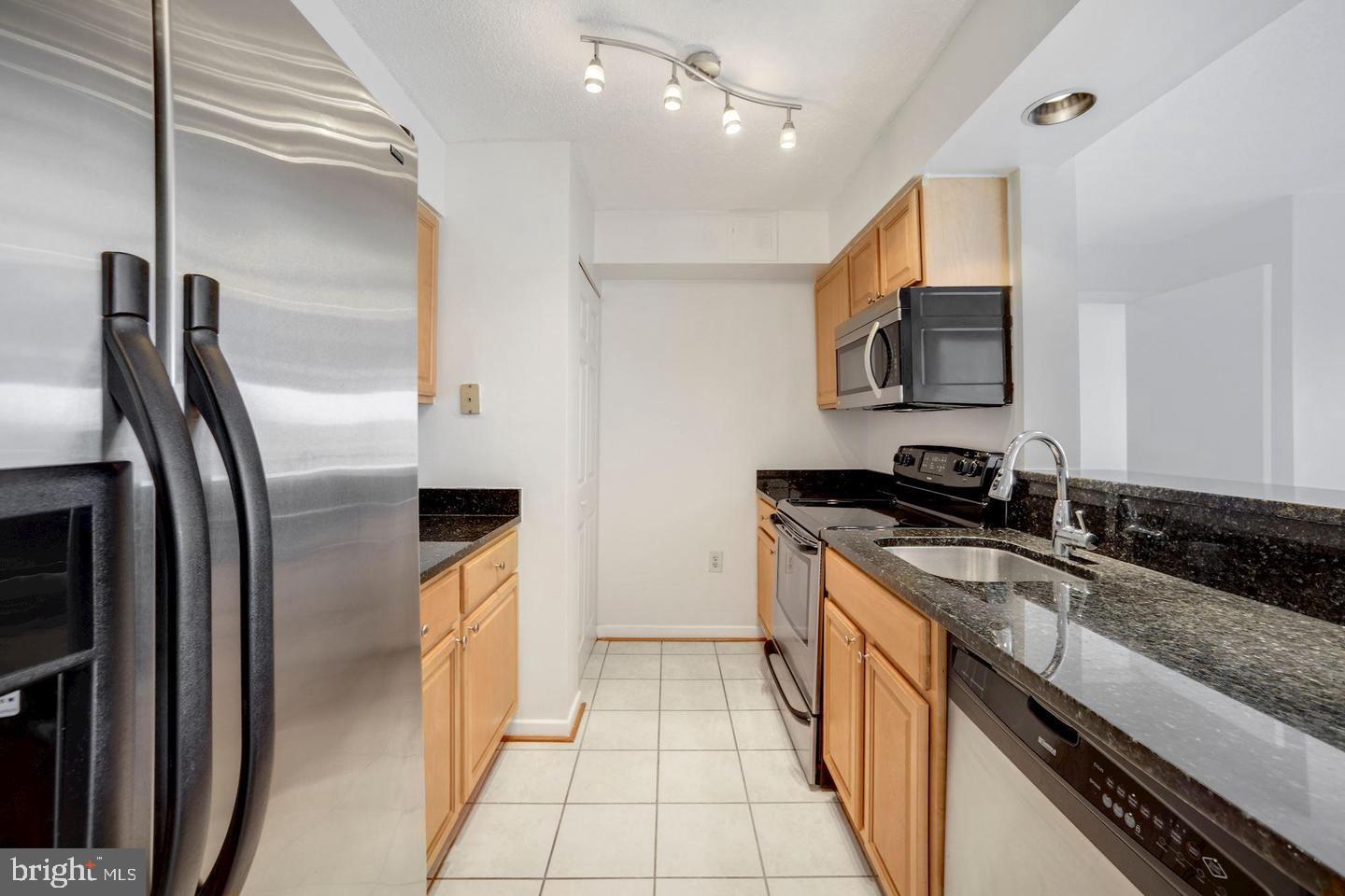 2111 Wisconsin Avenue Northwest, Unit 317 Washington, DC 20007 - Photo 16 of 38 a kitchen with granite countertop a refrigerator and a sink