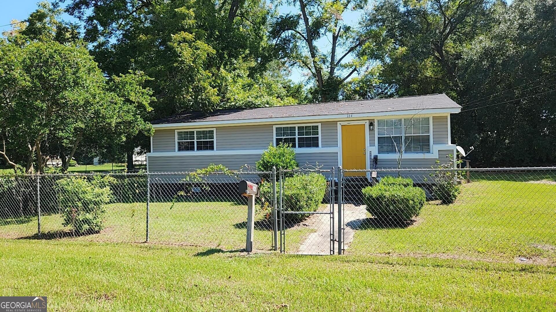 a view of house with backyard and a tree