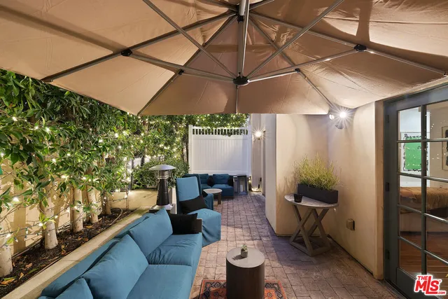 a outdoor living space with furniture and a black umbrella