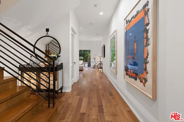a view of a hallway with wooden floor and furniture