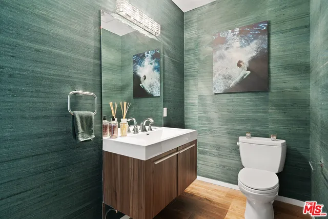 a bathroom with a toilet sink and mirror
