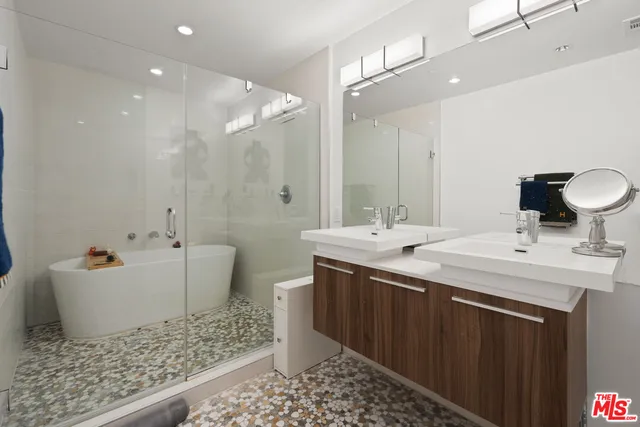 a bathroom with a double vanity sink mirror and bathtub