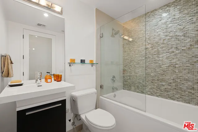 a bathroom with a sink toilet vanity and shower